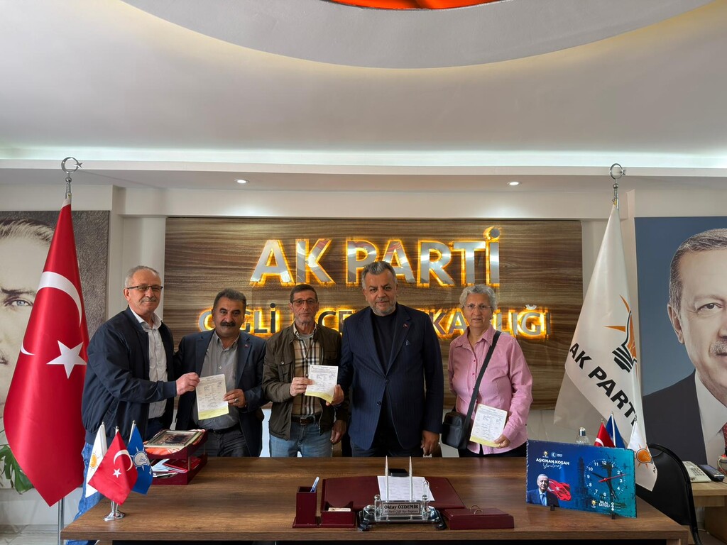 Dursun Ali Kazar, AK Parti Çiğli İlçe Başkanı Oktay Özdemir ile katılım evraklarını imzalarken.