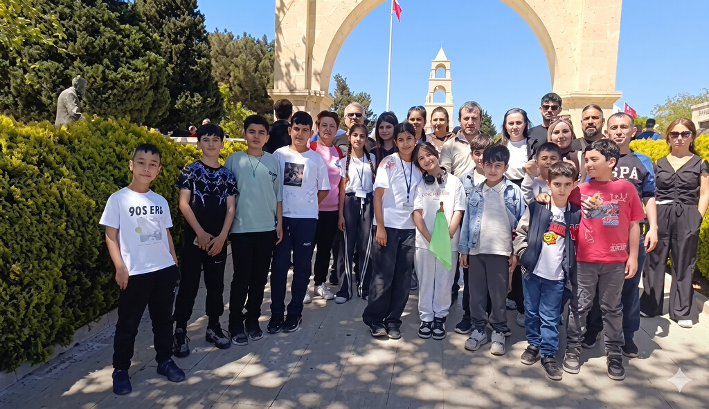 Çiğli Güzeltepe Ortaokulu öğrencileri ve öğretmenleri Çanakkale Şehitliği yolunda bayraklarla yürüyor.