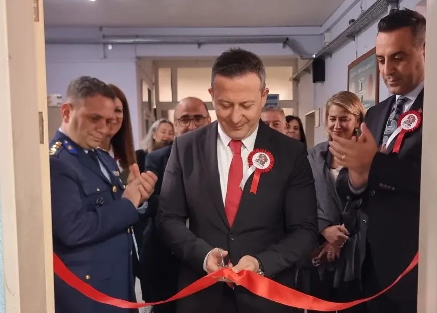 Çiğli Kaymakamı Fatih Görmüş elinde makasla kırmızı kurdele keserken, yanında Belediye Başkanı Onur Emrah Yıldız ve arkasında diğer protokol üyeleri sergi açılışı gerçekleştiriyor.