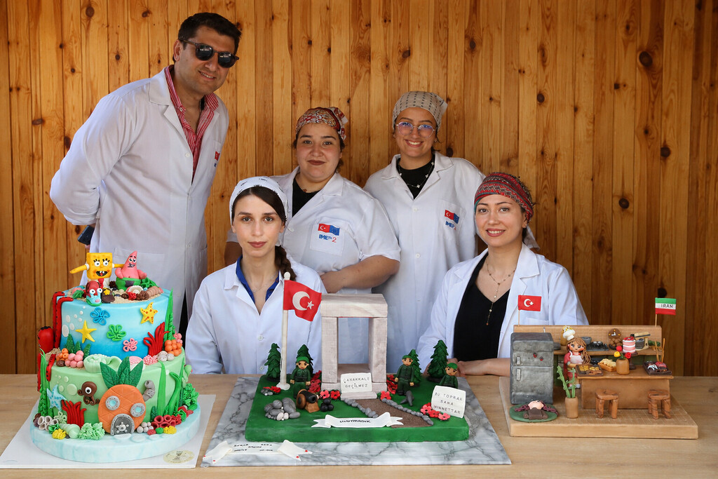 Çiğli Belediyesi istihdam garantili pastacılık kursu yarışmasında dereceye giren Su Altı Gizemi, Çanakkale Konseptli ve Minyatür İran Türk Mutfağı pastaları ile kursiyerlerin bir aradaki fotoğrafı.