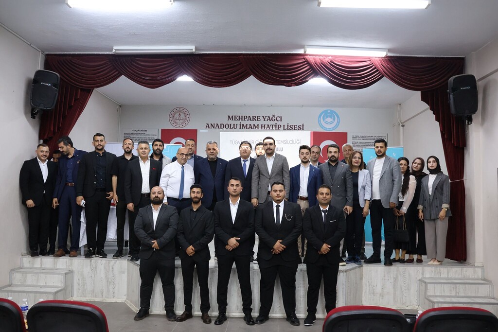 TÜGVA Çiğli 2. Olağan Genel Kurulu sonrasında sahnede protokol üyeleri, yönetim kurulu ve gençlerin katılımıyla gerçekleştirilen toplu anı fotoğrafı çekimi.