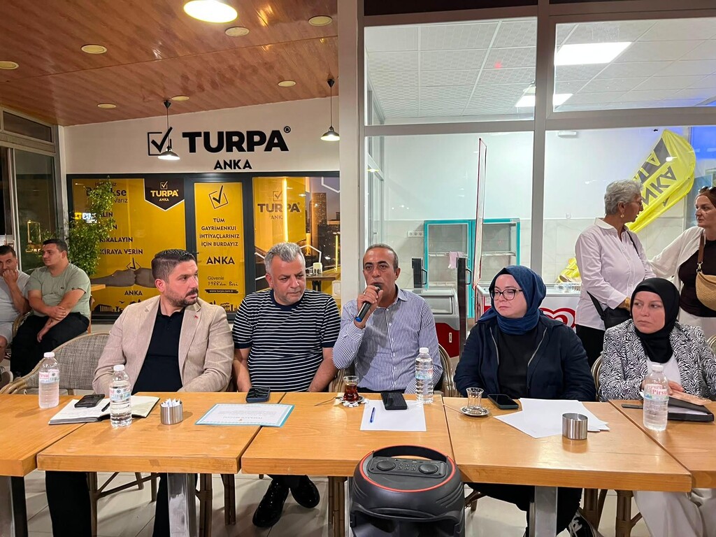 MHP Çiğli İlçe Başkanı Orhan Yılmaz, Cumhuriyet Mahallesi buluşmasında mikrofonla konuşma yaparken.